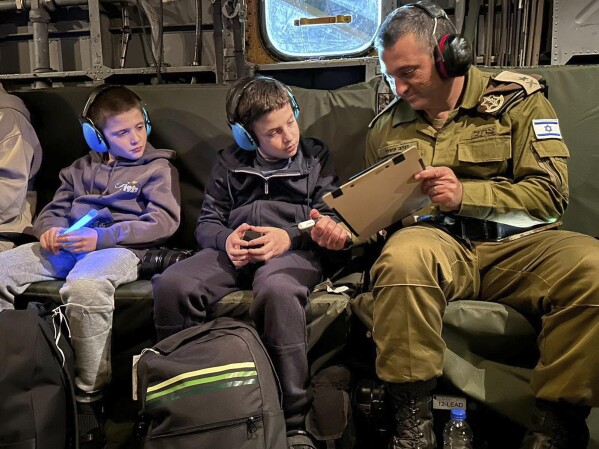 In this handout photo provided by the IDF on Monday, Nov. 27, 2023, Israeli hostages were released Tal Goldstein Almog, 9, left, and his brother Gal, 11, are seen returning to Israel in an IAF helicopter after being taken hostage by the terrorist goes.  The group Hamas in the Gaza Strip.  (IDF via AP)