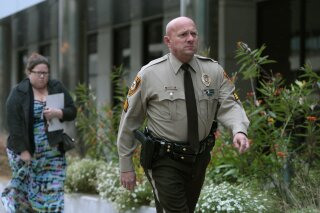 FILE - In this Oct. 24, 2019 file photo, St. Louis County police Sgt. Keith Wildhaber returns from a lunch break to the St. Louis County courthouse on the third day of his discrimination case against the county in Clayton, Mo.  St. Louis County has agreed to a $10.25 million settlement with Wildhaber, a gay police lieutenant who says he was passed over for promotion 23 times and was told to “tone down” his “gayness." The agreement with Wildhaber was finalized Monday, Feb. 11, 2020, hours after St. Louis County Police Chief Jon Belmar announced he is retiring, the St. Louis Post-Dispatch reported. (Cristina M. Fletes/St. Louis Post-Dispatch via AP, File)
