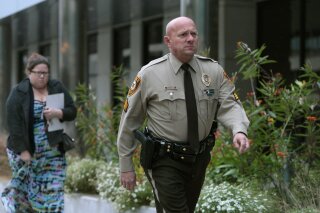 FILE - In this Oct. 24, 2019 file photo, St. Louis County police Sgt. Keith Wildhaber returns from a lunch break to the St. Louis County courthouse on the third day of his discrimination case against the county in Clayton, Mo. St. Louis County has agreed to a $10.25 million settlement with Wildhaber, a gay police lieutenant who says he was passed over for promotion 23 times and was told to “tone down” his “gayness." The agreement with Wildhaber was finalized Monday, Feb. 11, 2020, hours after St. Louis County Police Chief Jon Belmar announced he is retiring, the St. Louis Post-Dispatch reported. (Cristina M. Fletes/St. Louis Post-Dispatch via AP, File)