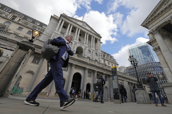ARCHIVO - Un hombre pasa frente al Banco de Inglaterra en el distrito financiero de Londres, 11 de mayo de 2023. (AP Foto/Frank Augstein)