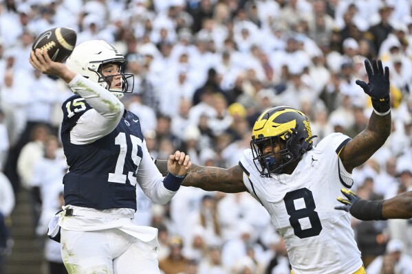 Michigan defensive end Derrick Moore (8) pressures Penn State quarterback Drew Allar (15) during the second half of an NCAA college football game, Saturday, Nov. 11, 2023, in State College, Pa. (AP Photo/Barry Reeger)