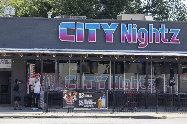 This July 2, 2023 file photo shows people talking in front of the City Nightz nightclub in Wichita, Kan. Police have arrested another person in the Kansas night club shooting earlier this month that injured nearly a dozen people. A 23-year-old Wichita man was arrested Tuesday, July 11, 2023 on suspicion of attempted murder, assault and battery, Wichita police said. He is one of three people now in custody for their suspected roles in the July 2 shooting in which nine people were shot and two others were trampled in the chaos. (Travis Heying/The Wichita Eagle via AP, file)