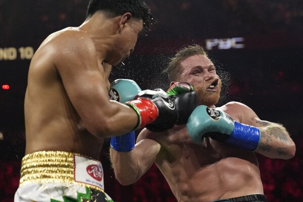 Jaime Munguia lands a left-handed blow to Canelo Alvarez in a super middleweight title fight on Saturday, May 4, 2024 in Las Vegas.  (AP Photo/John Locher)
