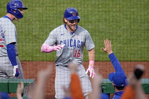 Chicago Cubs' Patrick Wisdom (16) returns to the dugout after hitting a two-run home run off Pittsburgh Pirates relief pitcher Aroldis Chapman during the tenth inning of a baseball game in Pittsburgh, Sunday, May 12, 2024. (AP Photo/Gene J. Puskar)