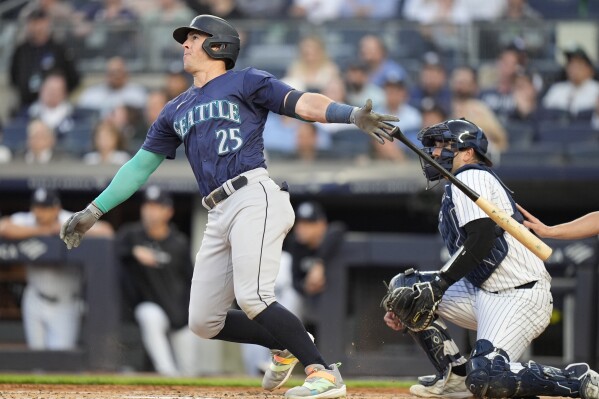 New York Yankees catcher Austin Wells watches as Seattle Mariners' Dylan Moore (25) follows through on a two-run home run during the third inning of a baseball game, Tuesday, May 21, 2024, in New York. (AP Photo/Frank Franklin II)