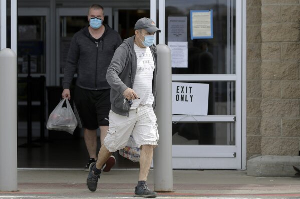 Men wearing protective masks during the coronavirus pandemic exit a Walmart, Wednesday, May 6, 2020, in Walpole, Mass. An executive order signed the previous week by Gov. Charlie Baker took effect Wednesday mandating the use of masks when individuals are not able to socially distance themselves from others. (AP Photo/Steven Senne)