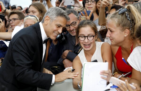 
              George Clooney signs autographs upon his arrival at the premiere of the film 'Suburbicon' during the 74th edition of the Venice Film Festival in Venice, Italy, Saturday, Sep. 2, 2017. (AP Photo/Domenico Stinellis)
            