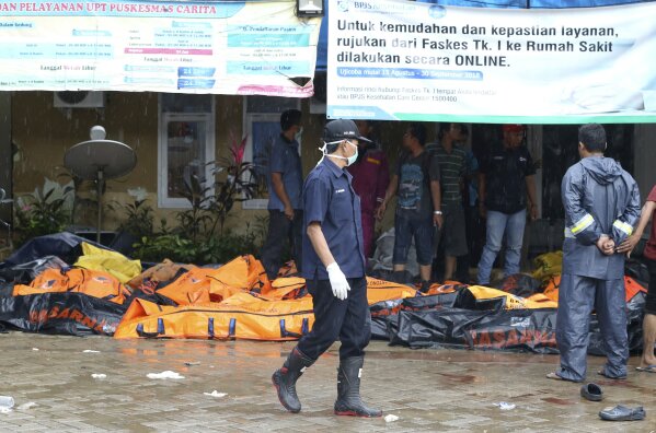 
              Wrapped bodies of tsunami victims are laid in Carita, Indonesia, Sunday, Dec. 23, 2018. The tsunami occurred after the eruption of a volcano around Indonesia's Sunda Strait during a busy holiday weekend, sending water crashing ashore and sweeping away hotels, hundreds of houses and people attending a beach concert. (AP Photo/Achmad Ibrahim)
            