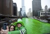 FILE - Stacey Peterson and Kevin McGuire take a selfie in front of the green Chicago River to celebrate St. Patrick's Day, Saturday, March 17, 2018. The Chicago River has turned a bright shade of green, kicking off St. Patrick's Day. Patrick of the city.  Festivities of the day.  The day honoring Ireland's patron saint is a global celebration of Irish heritage.  And nowhere is this more true than in the United States, where parades take place in cities across the country and all types of food and drink take on an emerald hue.  (James Foster/Chicago Sun-Times via AP, file)