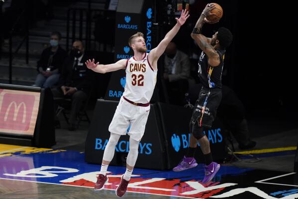 Cleveland Cavaliers' Dean Wade, left, defends Brooklyn Nets' Kyrie Irving, right, during the second half of an NBA basketball game Sunday, May 16, 2021, in New York. (AP Photo/Frank Franklin II)