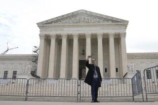 A visitor takes a selfie in front of the Supreme Court building on Capitol Hill, Monday, March 27, 2023, in Washington. (AP Photo/Mariam Zuhaib)