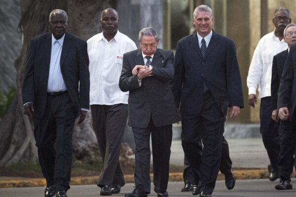 
              Cuba's President Raul Castro, center, looks at his watch while he walks with Cuba's Vice President Miguel Diaz-Canel and the President of the National Assembly of People's Power, Esteban Lazo Hernandez, left, upon his arrival for a ceremony to unveil a replica of a statue of Cuba's independence hero Jose Marti in Havana, Cuba, Sunday, Jan. 28, 2018. The monument was unveiled on the 165th anniversary of the birth of the Cuban independence hero. (AP Photo/Ramon Espinosa)
            