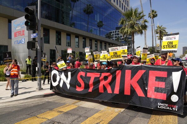 Striking Hotel workers from Unite Here Local 11 join the picketing actors of SAG-AFTRA, and writers of the WGA, outside Netflix studios on July 21, 2023, in Los Angeles. Some Democrats in the California Legislature are trying to change the law to make striking workers eligible for unemployment benefits. Business groups oppose the bill, noting California doesn't have enough money in its unemployment trust fund to pay for benefits now. (AP Photo/Chris Pizzello, File)