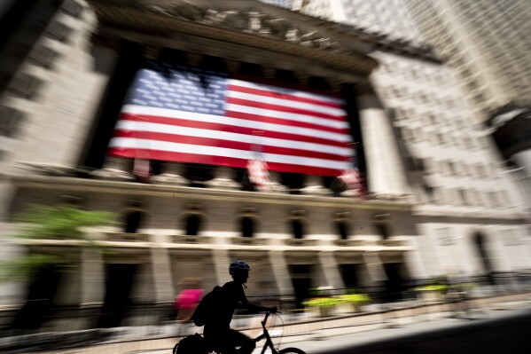 A person bikes past the New York Stock Exchange on Wednesday, June 29, 2022 in New York. Stocks shifted between gains and losses on Wall Street Wednesday, keeping the market on track for its fourth monthly loss this year. (AP Photo/Julia Nikhinson)