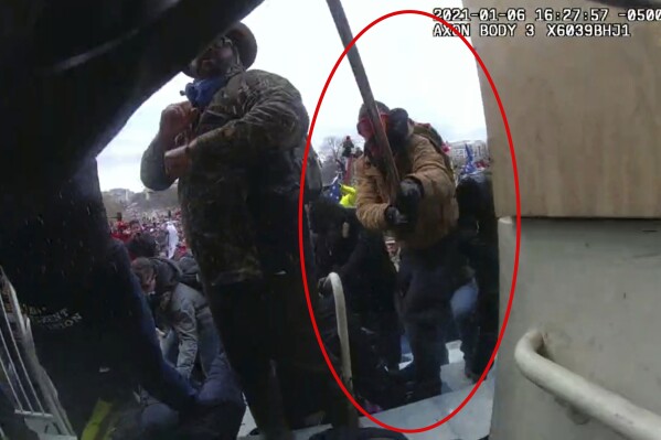 This image from police body-worn camera video, contained and annotated in the Justice Department's government's sentencing memorandum supporting the sentencing of Scott Miller, shows Miller at the U.S. Capitol on Jan. 6, 2021, in Washington. U.S. District Judge Tanya Chutkan sentenced Miller, of Millersville, Md., a former Proud Boys chapter leader, to five years and six months behind bars. Prosecutors say notes found on Miller’s cellphone indicate that his white supremacist ideology and antisemitic views influenced his decision to storm the Capitol. (Department of Justice via AP)