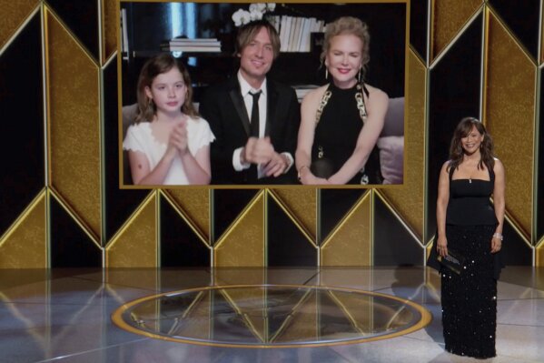 In this video grab issued Sunday, Feb. 28, 2021, by NBC, Nicole Kidman, nominee for best actress in a limited series for "The Undoing" appears on screen, from right, with her husband Keith Urban and their daughter Faith Margaret Kidman Urban as presenter Rosie Perez looks on at the Golden Globe Awards. (NBC via AP)
