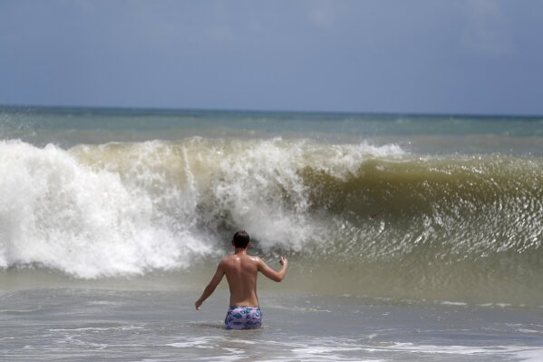 A person plays in the high surf form the Atlantic Ocean on the barrier island in Vero Beach, Fla., Sunday, Sept. 1, 2019. The barrier island is under a voluntary evacuation today and a mandatory evacuation tomorrow in preparation for the possibility of Hurricane Dorian making landfall. (AP Photo/Gerald Herbert)