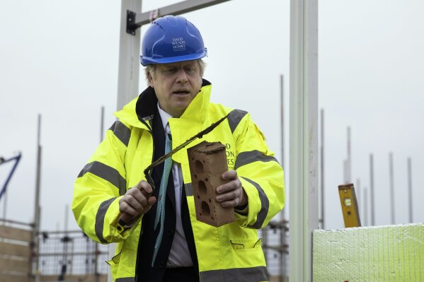 Britain's Prime Minister Boris Johnson lays a brick during a visit to the Barratt Homes - Willow Grove housing development in Bedford, England, Thursday, Nov. 21, 2019. Britain’s main opposition Labour Party promised Thursday to radically expand public spending and state ownership if it wins the Dec. 12 election, trying to close an opinion-poll gap with the governing Conservatives (Dan Kitwood/Pool photo via AP)
