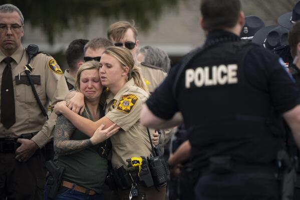 Law enforcement members comfort each other after St. Croix County Deputy Kaitie Leising's body was carried into a Baldwin, Wis., funeral home Sunday afternoon, May 7, 2023. Leising was shot and killed during a traffic stop Saturday. (Jeff Wheeler/Star Tribune via AP)
