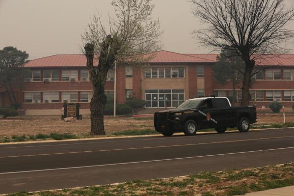 A New Mexico State Police vehicle drives by the New Mexico State Hospital in Las Vegas, N.M., a mental care facility, which was evacuated, Monday, May 2, 2022. Wind-whipped flames are marching across more of New Mexico's tinder-dry mountainsides, forcing the evacuation of area residents and dozens of patients from the state's psychiatric hospital as firefighters scramble to keep new wildfires from growing. (AP Photo/Cedar Attanasio)
