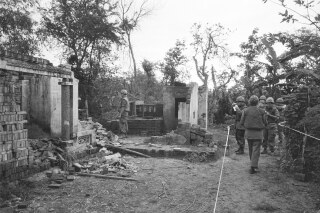 American soldiers look over the remains of a home in My Lai, South Vietnam in this Jan. 8, 1970 file photo. The GIs are in a safe area marked off with white tape, having been swept for booby-traps that have already wounded five soldiers since the investigation of the killing of unarmed civilians by members of the U.S. Army; what would come to be called The My Lai Massacre, began. (AP Photo/File)