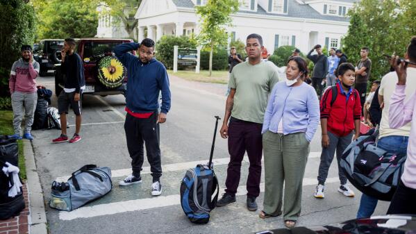 FILE - Migrants, who arrived on a flight sent by Florida Gov. Ron DeSantis, gather with their belongings outside St. Andrews Episcopal Church, Wednesday Sept. 14, 2022, in Edgartown, Mass., on Martha's Vineyard. A Texas sheriff on Monday, Sept. 19 opened an investigation into two flights of migrants sent to Martha's Vineyard by DeSantis, but did not say what laws may have been broken in putting 48 Venezuelans on private planes last week from San Antonio. (Ray Ewing/Vineyard Gazette via AP, File)