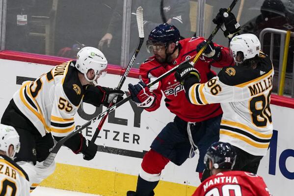 Boston Bruins defensemen Jeremy Lauzon (55) and Kevan Miller (86) combine to defend against Washington Capitals left wing Alex Ovechkin (8) during the second period of Game 1 of an NHL hockey Stanley Cup first-round playoff series Saturday, May 15, 2021, in Washington. (AP Photo/Alex Brandon)