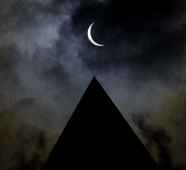 The moon is seen passing in front of the sun with the top of the Washington Monument in silhouette during a solar eclipse in Washington on Monday, April 8, 2024. (Bill Ingalls/NASA via AP)