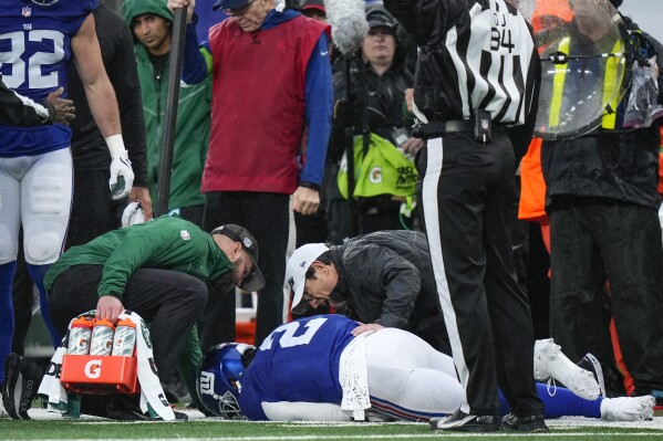 New York Giants quarterback Tyrod Taylor (2) lies on the New York Jets sidelines with an apparent injury during the first half of an NFL football game, Sunday, Oct. 29, 2023, in East Rutherford, N.J. (AP Photo/Frank Franklin II)