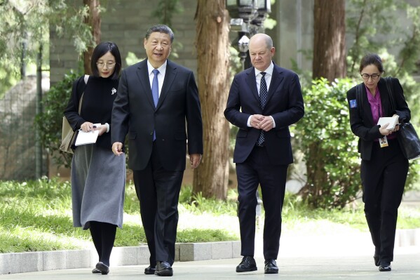 In this photo released by Xinhua News Agency, Chinese President Xi Jinping, second from left, and German Chancellor Olaf Scholz, second from right, walk together in Beijing, China, on Tuesday, April 16, 2024. (Ding Haitao/Xinhua via AP)