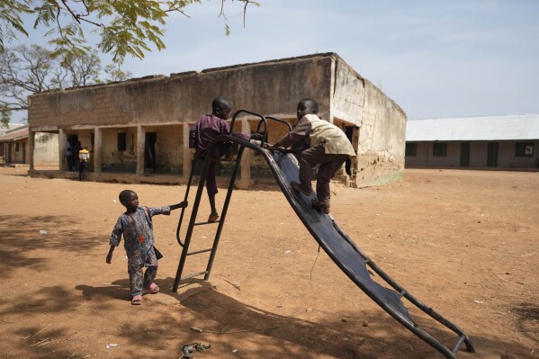 Children play at the LEA Primary and Secondary School Kuriga where students were kidnapped in Kuriga, in Kaduna state, Nigeria, Saturday, March 9, 2024. Security forces swept through large forests in Nigeria's northwest region on Friday in search of nearly 300 children who were abducted from their school a day earlier in the West African nation's latest mass kidnap which analysts and activists blamed on the failure of intelligence and slow security response. (AP Photo/Sunday Alamba)