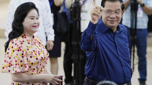 Cambodian Prime Minister Hun Sen, right, of the Cambodian People's Party (CPP) shows off his inked finger, standing next to his wife Bun Rany, left, after voting a ballot at a polling station in Takhmua in Kandal province, southeast Phnom Penh, Cambodia, Sunday, July 23, 2023. Cambodians go to the polls Sunday with incumbent Prime Minister Hun Sen and his party all but assured a landslide victory thanks to the effective suppression and intimidation of any real opposition that critics say has made a farce of democracy in the Southeast Asian nation. (AP Photo/Heng Sinith)