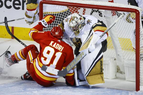 Vegas Golden Knights goalie Logan Thompson, right, falls back into the net as Calgary Flames forward Nazem Kadri crashes into him during the second period of an NHL hockey game Tuesday, Oct. 18, 2022, in Calgary, Alberta. (Jeff McIntosh/The Canadian Press via AP)