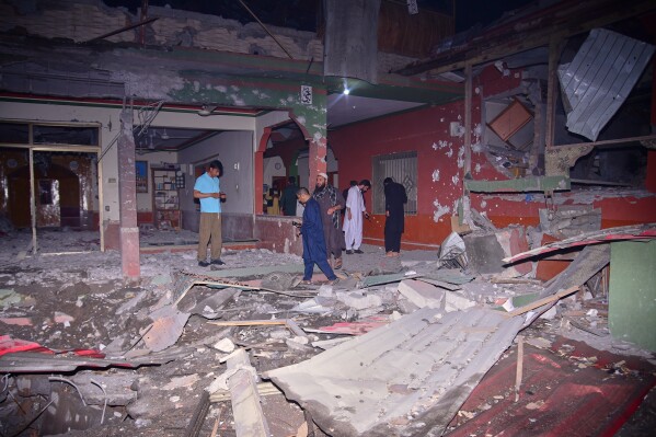 Local residents and members of the media examine a building damaged by a suspected Indian missile attack near Muzaffarabad, the capital of Pakistan controlled Kashmir, in Wednesday, May 7, 2025. (AP Photo/M.D. Mughal)