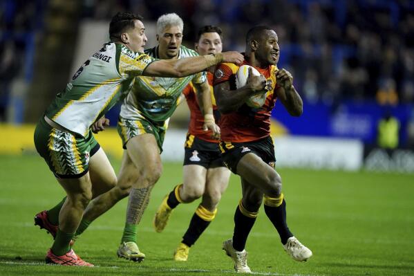 Papau New Guinea's Edwin Ipape is tackled by Cook Islands' Brad Takairangi during the Rugby League World Cup group D match between Papua New Guinea and Cook Islands at The Halliwell Jones Stadium, Warrington, England, Tuesday Oct. 25, 2022. (Mike Egerton/PA via AP)