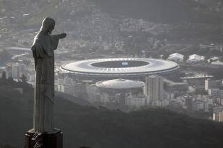 FILE - This May 13, 2014 file photo shows Maracana stadium behind the Christ the Redeemer statue in Rio de Janeiro, Brazil. Brazil will host Copa America for the second consecutive time after Colombia and Argentina were stripped of hosting rights for the tournament, according to the South American soccer body CONMEBOL on Monday, May 31, 2021, hours after it ruled out Argentina amid an increase in COVID-19 cases in the country. Colombia was removed as co-host on May 20 as street protests against President Iván Duque rocked the nation. (AP Photo/Felipe Dana, File)