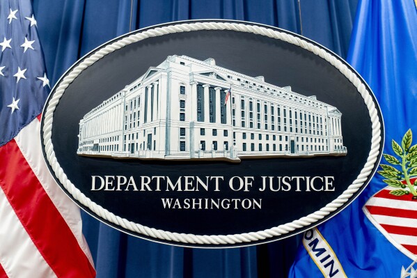 FILE - The seal for the Justice Department is photographed in Washington, Nov. 18, 2022. The Justice Department has announced three arrests in a complex stolen identity scheme that officials say generates enormous proceeds for the North Korean government, including for its weapons program. (AP Photo/Andrew Harnik, File)