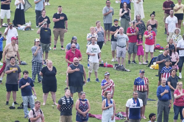 People attend a military parade commemorating the Army's 250th anniversary and coinciding with President Donald Trump's 79th birthday, Saturday, June 14, 2025, in Washington. (AP Photo/Jacquelyn Martin)