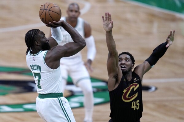 Boston Celtics guard Jaylen Brown (7) shoots as Cleveland Cavaliers' Donovan Mitchell defends during the first half of Game 1 of an NBA basketball second-round playoff series Tuesday, May 7, 2024, in Boston. (AP Photo/Charles Krupa)