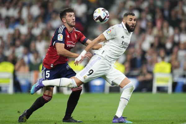 FILE - Osasuna's David Garcia, left, challenges for the ball with Real Madrid's Karim Benzema during the Spanish La Liga soccer match between Real Madrid and Osasuna at the Santiago Bernabeu stadium in Madrid, Spain, Sunday, Oct. 2, 2022. Real Madrid will need to rediscover its winning form come Saturday May 6, 2023 when it faces Osasuna in the Copa del Rey final. Carlo Ancelotti's team has struggled in the Spanish league ahead of the crucial stretch of games starting with the cup final that will determine whether Madrid's season ends in success or failure. (AP Photo/Manu Fernandez, File)