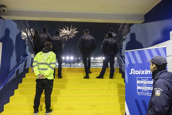 FILE - In this Sunday, Dec. 17, 2023, file photo, Greek police secure an entrance of a stadium during a Greek super League soccer match between Atromitos and Panathinaikos, at Peristeri stadium, in Athens, Greece. Greek authorities on Tuesday, April 9, 2024, have launched a ban on paper tickets at all top flight soccer matches as part of an effort to crack down on violence that has plagued the sport for decades. (AP Photo/Yorgos Karahalis, File)