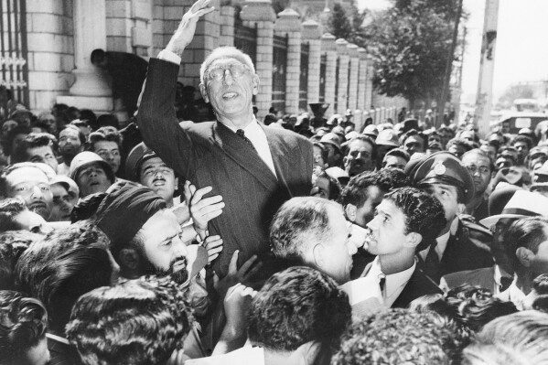 FILE - Prime Minister Mohammad Mossadegh rides on the shoulders of cheering crowds in Tehran's Majlis Square, outside the parliament building, after reiterating his oil nationalization views to his supporters on Sept. 27, 1951. While revealing new details about one of the most famed CIA operations of all times, the spiriting out of six American diplomats who escaped the 1979 U.S. Embassy seizure in Iran, the intelligence agency for the first time has acknowledged something else as well. The CIA now officially describes the 1953 coup it backed in Iran that overthrew its prime minister and cemented the rule of Shah Mohammad Reza Pahlavi as undemocratic. (AP Photo, File)