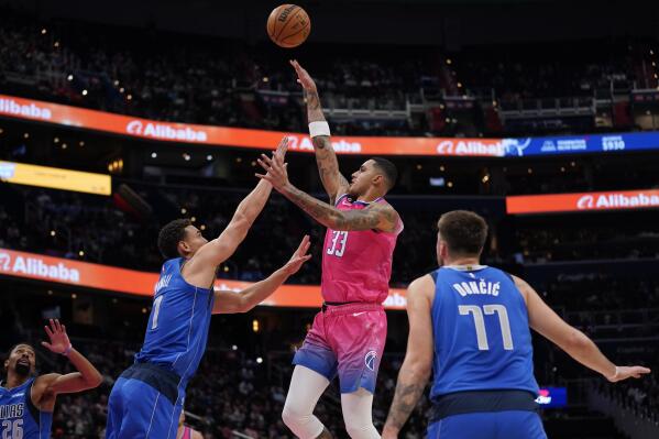 Washington Wizards forward Kyle Kuzma (33) shoots over Dallas Mavericks guard Spencer Dinwiddie, from left, center Dwight Powell and guard Luka Doncic, of Slovenia, in the first half of an NBA basketball game, Thursday, Nov. 10, 2022, in Washington. (AP Photo/Patrick Semansky)