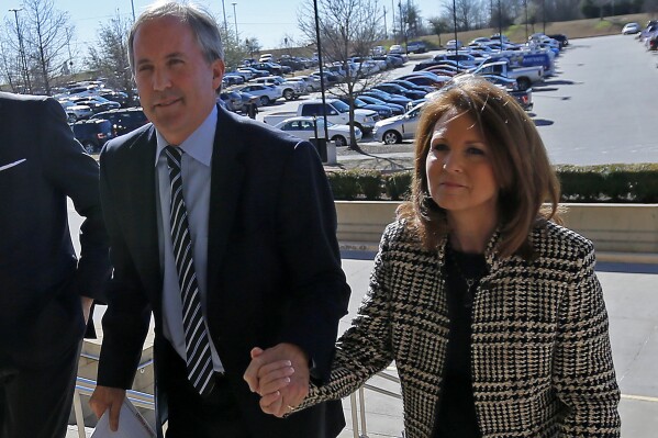 FILE - Texas Attorney General Ken Paxton, left, arrives at the Collin County Courthouse with his wife, Angela Paxtion, Feb. 16, 2017, in McKinney, Texas. The Texas Senate is set to gavel in Tuesday, Sept. 5, 2023, for the impeachment trial of state Attorney General Ken Paxton, a formal airing of corruption allegations that could lead Republican lawmakers to oust one of their own as lead lawyer for America's largest red state. Among the senators is Paxton's wife, Angela. Trial rules don't allow her to participate or to vote. But her presence, which is mandated by the state Constitution, means she counts toward the total needed to convict her husband. (Jae S. Lee/The Dallas Morning News via AP, File)