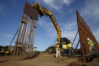 
              FILE - In this Jan. 9, 2019 file photo, construction crews install new border wall sections seen from Tijuana, Mexico. Sen. Dick Durbin, D-Ill., says the Pentagon is planning to tap $1 billion in leftover funds from military pay and pensions accounts to help President Donald Trump pay for his long-sought border wall. Durbin told The Associated Press, “it’s coming out of military pay and pensions, $1 billion, that’s the plan.”(AP Photo/Gregory Bull, File)
            