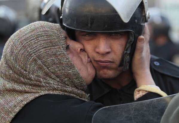 An Egyptian anti-government activist kisses a riot police officer following clashes in Cairo, Egypt, on Jan. 28, 2011. (AP Photo/Lefteris Pitarakis, File)