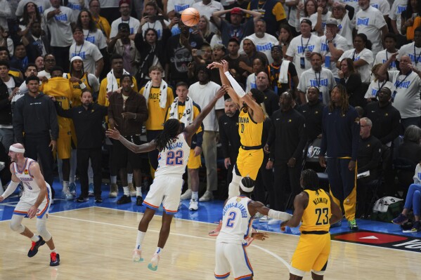 Indiana Pacers guard Tyrese Haliburton (0) shoots a 3-pointer against Oklahoma City Thunder guard Cason Wallace (22) during the second half of Game 1 of the NBA Finals basketball series Thursday, June 5, 2025, in Oklahoma City. (AP Photo/Nate Billings)