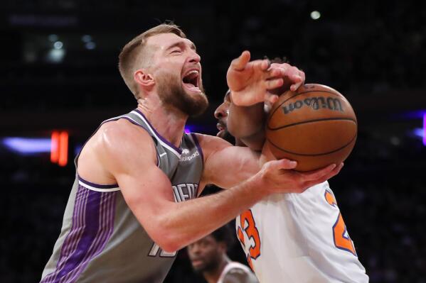 Sacramento Kings forward Domantas Sabonis is fouled by New York Knicks center Mitchell Robinson (23) during the first half of an NBA basketball game, Sunday, Dec. 11, 2022, in New York. (AP Photo/Noah K. Murray)