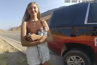 FILE - This police camera video provided by The Moab Police Department shows Gabrielle "Gabby" Petito talking to a police officer after police pulled over the van she was traveling in with her boyfriend, Brian Laundrie, near the entrance to Arches National Park on Aug. 12, 2021.  Teton County Coroner Brent Blue is scheduled to announce the findings of Petito's autopsy at a news conference early Tuesday, Oct. 12. (The Moab Police Department via AP)