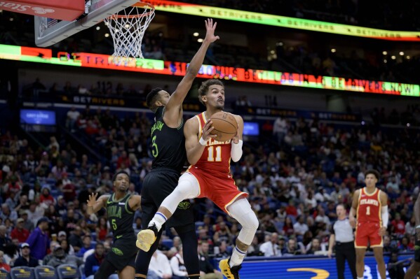 Atlanta Hawks guard Trae Young (11) looks to pass as New Orleans Pelicans guard CJ McCollum (3) defends during the second half of an NBA basketball game in New Orleans, Saturday, Nov. 4, 2023. (AP Photo/Matthew Hinton)